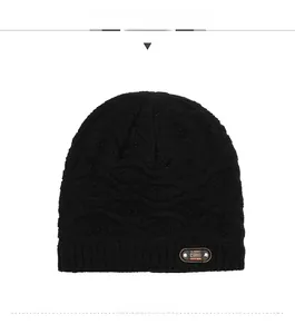 Close-up of black knitted beanie with honeycomb texture and brown leather classic logo