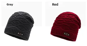 Detail of gray and red knit beanies featuring thick ribbed cuffs and leather logo patches