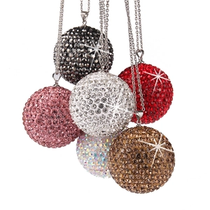 Macro view of six sparkling crystal-encrusted spherical car pendants in multiple colors