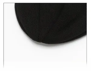 Detailed close-up of heavy-duty reinforced stitching on top of a black knitted beanie