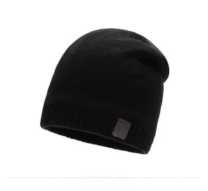 Close-up of black knit winter beanie with detailed sport leather patch and star pattern