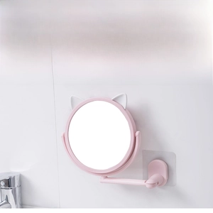 Pink cat-ear vanity mirror with wall-mounted retractable bracket on white bathroom tiles