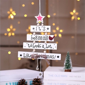 Christmas wooden tree hanging sign with bells and festive text on a warm light background