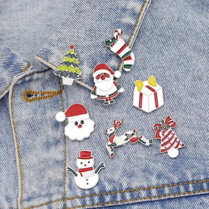 Detailed view of colorful enamel Christmas pins on a denim jacket featuring Santa and trees
