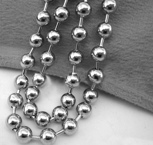 Detail shot of silver stainless steel ball chain necklace on gray velvet background