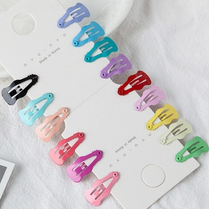 Close-up of 14 colorful rainbow metal hair clips neatly arranged on a display card