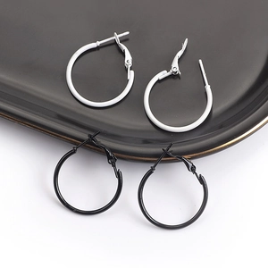 Close-up of classic black and white metal hoop earrings on a high-contrast background