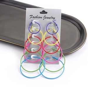 Close-up of 6 pairs of colorful round hoop earrings set in various sizes and vibrant finishes