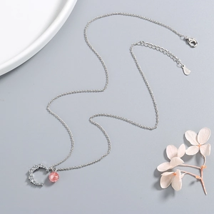Elegant moon pendant necklace with pink strawberry crystal on a minimalist silver chain