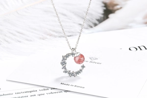 Detail of moon pendant featuring pink strawberry quartz and sparkling zircons on silver chain