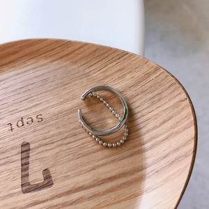 Detailed top view of a minimalist 925 sterling silver beaded ring on a wooden display tray