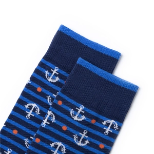 Detail of navy blue nautical socks with anchor patterns and orange dots on knit fabric