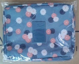 Detail of travel makeup bag with blue floral pattern and waterproof storage feature