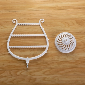 Assembled white plastic harp-shaped jewelry organizer with circular base components