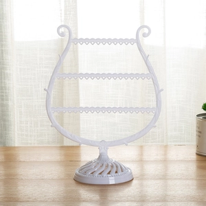 Detailed view of white harp-shaped jewelry organizer with multi-tier earring holes