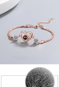 Rose gold heart projection bracelet with 100 languages stone and white zircon details