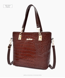 Detail of deep brown crocodile texture handbag with gold MeiSege logo and metallic lock
