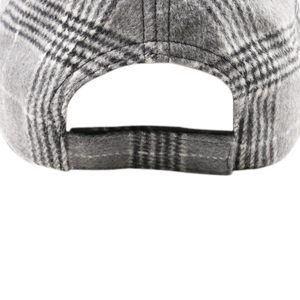 Close-up of adjustable hook and loop closure on a red and black plaid wool baseball cap