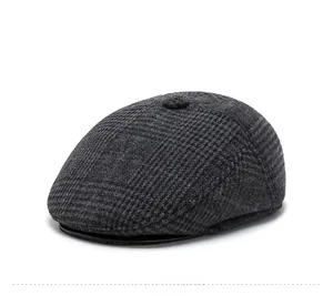Détail d'une casquette plate à carreaux gris foncé pour homme en laine texturée d'hiver