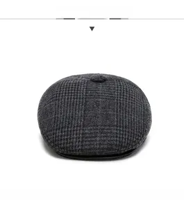Vue frontale du béret gris à carreaux montrant le tissu chaud et le bouton supérieur