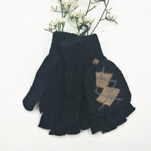 Détail de gants noirs tricotés à rabat avec motif géométrique et demi-doigts