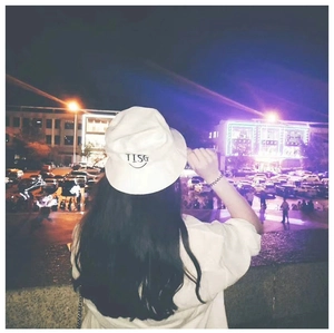 Close-up of black TISG embroidery and smiley face on a white cotton bucket hat