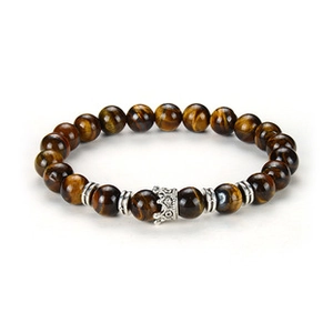 Macro view of a brown tiger eye beaded bracelet featuring a silver crown charm detail