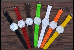 Flat lay of colorful ultra-thin silicone jelly watches on a textured wood surface