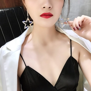 Sparkling oversized star drop earrings with white rhinestones on fashion model