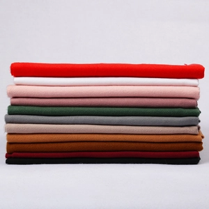 Solid cashmere-feel scarves with fringe tassels displayed in multiple vibrant colors
