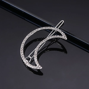 Elegant silver crescent moon hair clip with sparkling rhinestones on a black background