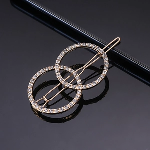 Detail of interlocking golden metal rings hair clip with pavé set white rhinestones
