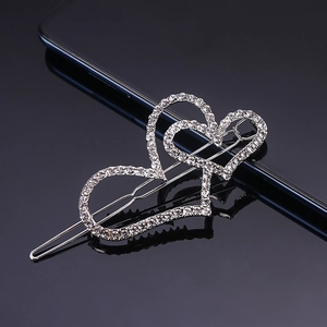 Macro detail of silver hair clip featuring double heart shapes with sparkling rhinestones