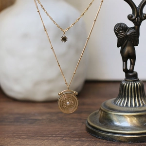 Detail of gold double-layer necklace with vintage Roman pendant on bronze statue