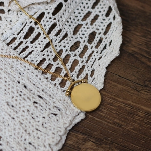 Close-up of vintage 18K gold plated double layer necklace on white lace and wood background