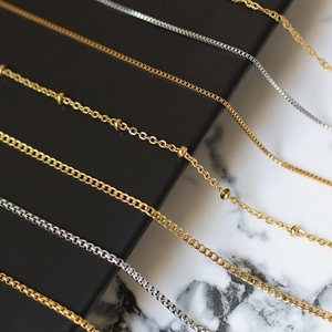 Close-up of gold and silver titanium steel chains showing various link textures