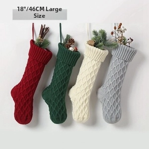 Macro detail of four 18-inch cable-knit Christmas stockings in red, green, white and grey