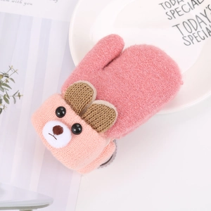 Close-up of pink knit baby mitten featuring a cute bear design on a decorative plate