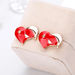 Detail view of heart-shaped Christmas earrings with red oil drip finish and santa hat decor