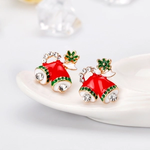 Macro view of colorful Christmas bell earrings with rhinestones on ceramic plate