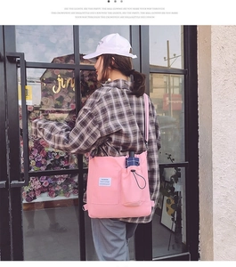 Pink canvas crossbody bag featuring large capacity and side pocket for umbrella