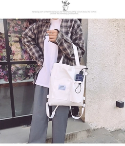 White canvas tote bag detail featuring large front pocket and side umbrella storage slot