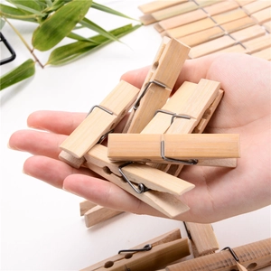 Handheld view of durable bamboo clothes pegs with strong metal springs for laundry drying