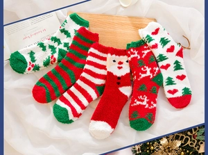 Close-up of five pairs of thick coral fleece Christmas socks in festive red and green colors