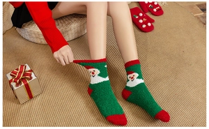 Close-up of thick coral fleece Christmas socks with festive Santa Claus embroidery