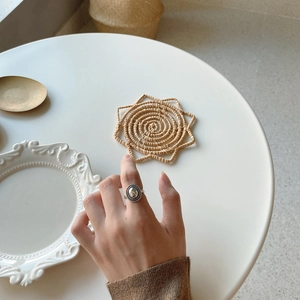 Close-up of minimalist 925 sterling silver oval ring on model hand with retro props