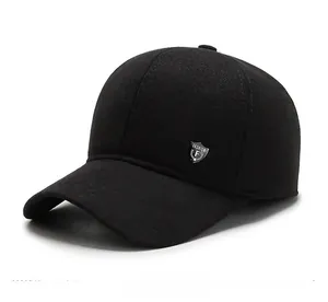 Dettaglio laterale di un cappello nero in lana con stemma metallico e tessuto termico
