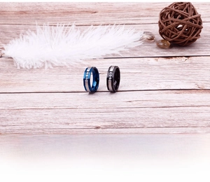 Close-up of minimalist two-tone stainless steel rings with three cubic zirconia stones