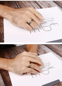 Close-up of men's titanium steel ring with silver body, blue center line and zircon inlay