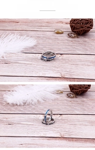 Detail of polished stainless steel rings featuring colored enamel lines and a small zircon